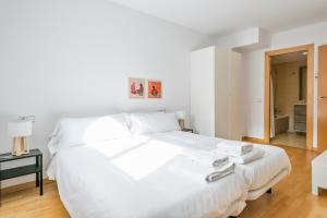 a white bedroom with a large white bed with white sheets at Inside Barcelona Apartments Princep in Barcelona