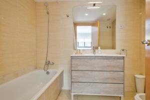 a bathroom with a tub and a sink and a mirror at Inside Barcelona Apartments Princep in Barcelona