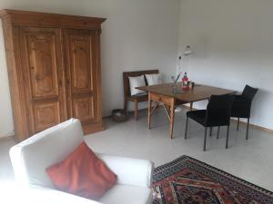 a living room with a white couch and a table at Ferienwohnung Kliniknähe mit Blick ins Grüne in Tübingen