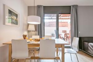 a dining room with a table and white chairs at Inside Barcelona Apartments Princep in Barcelona