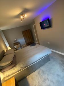 a bedroom with a bed and a tv on the wall at Town centre 3 bed luxury apartment in Wick +14 photos