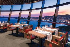a restaurant with tables and chairs and a view of the city at Hotel Olympia Sky in Vodice