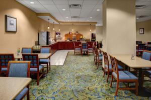 a restaurant with tables and chairs and a counter at Holiday Inn Express - Richmond Downtown, an IHG Hotel in Richmond