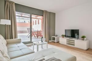a living room with a white couch and a television at Inside Barcelona Apartments Princep in Barcelona