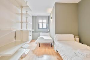 a white room with two beds and a table at Inside Barcelona Apartments Princep in Barcelona
