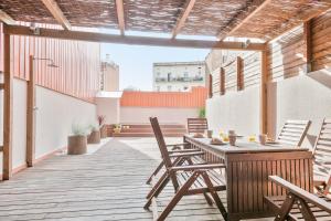 an outdoor patio with a wooden table and chairs at Inside Barcelona Apartments Princep in Barcelona