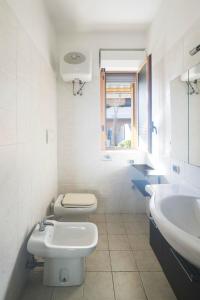 Baño blanco con lavabo y aseo en Cozy Apartment TAM, en Bari