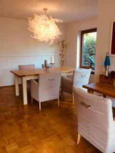comedor con mesa, sillas y lámpara de araña en Charmantes Garten-Apartment: Erholung im Chiemgau, en Unterwossen