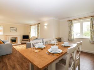 a dining room with a wooden table and chairs at Oakdene in Stratford-upon-Avon