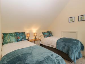 a bedroom with two beds and two lamps on a table at Oakdene in Stratford-upon-Avon