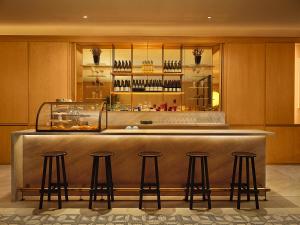 a bar in a restaurant with four bar stools at The Moore, New York City, a Member of Design Hotels in New York