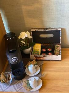 un tavolo con una macchinetta del caffè e una scatola di muffin di Home Relax a Cagliari