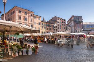 a group of people walking around an outdoor market at Campo De Fiori Relais in Rome