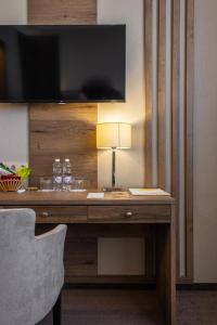 a desk in a hotel room with a television and a lamp at HELIOPARK Residence in Penza