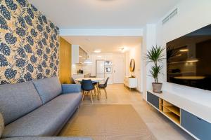 uma sala de estar com um sofá e uma sala de jantar em High class 2 Bedroom Apartment with underfloor heating em La Horadada