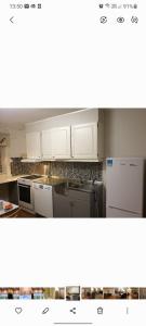 a kitchen with white cabinets and appliances at Honningsvåggt. 3H Apartement in Vardø
