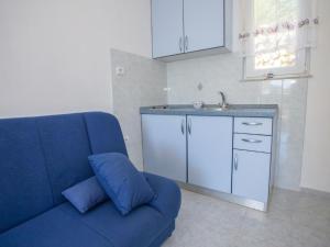 un sofá azul en una cocina con fregadero en Apartment Rea with Pool, en Brseč