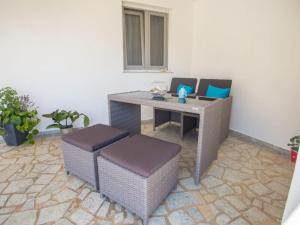 una mesa al aire libre con 2 sillas y una mesa con sillas en Apartment Rea with Pool, en Brseč