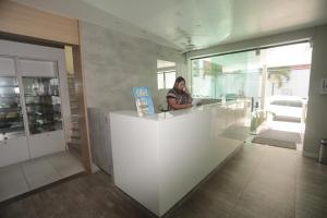 a woman sitting at a counter in a room at Navegantes Praia Hotel in Recife