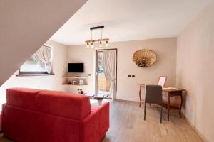 ein Wohnzimmer mit einem roten Sofa und einem Tisch in der Unterkunft Appartamento Livigno in Livigno