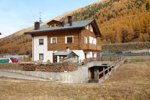 Appartamento Livigno في ليفينو: منزل فوق جدار حجري امام جبل