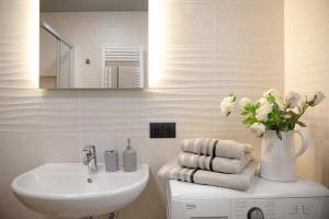 Appartamento Livigno في ليفينو: حمام مع حوض و مزهرية من الزهور +12 صورة