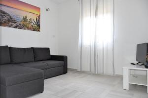 a living room with a couch and a tv at Apartment Meryl in Mravince