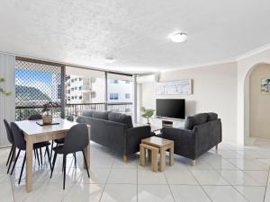 een woonkamer met banken en een tafel en een televisie bij Beachfront Getaway in Palm Beach in Gold Coast