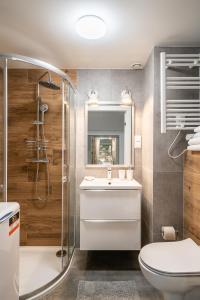 uma casa de banho com um WC, um lavatório e um chuveiro em RentPlanet - Apartamenty Zarembowicza em Breslávia