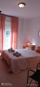 1 dormitorio con 1 cama grande y cortinas rosas en Top Rota Playa La Costilla Costa de la Luz, en Rota