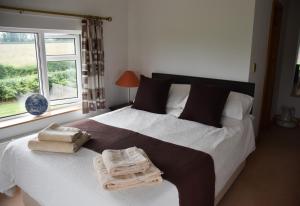 a bedroom with a large bed with towels on it at The Cottage, Poplars Farm in Ashbourne