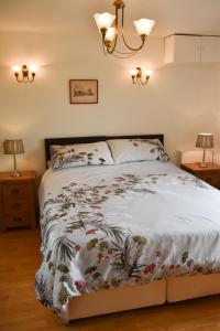 a bedroom with a bed with a white comforter at The Cottage, Poplars Farm in Ashbourne