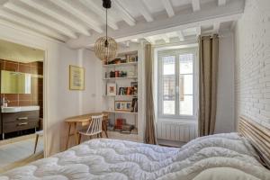 a bedroom with a bed and a sink and a table at Sea You Soon in Langrune-sur-Mer