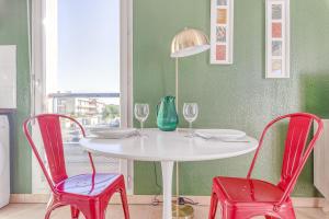 トゥールーズにあるLa Rosaceの白いテーブル(赤い椅子2脚付)と青い花瓶