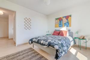 um quarto com uma cama e um quadro na parede em La Rosace em Toulouse