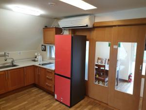 a kitchen with a red and black refrigerator at Namhae Neuhaus in Namhae