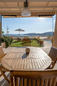einen Holztisch mit Stühlen und einem Sonnenschirm auf einer Terrasse in der Unterkunft Mirador Ca'n Rovira in Palma de Mallorca