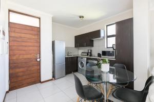 a kitchen with a glass table and chairs and a door at 2Bedroom apartment in a secure golf estate.WIFI in Roodepoort