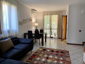 a living room with a blue couch and a table at Hotel Ulivi in Paratico