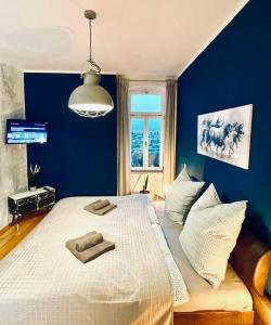 una camera da letto con un grande letto con pareti blu di Edle Ferienwohnung - Industrial Style a Dresda