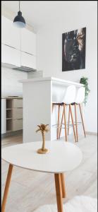 a white kitchen with a table and white chairs at Artemis Apartment in Ulcinj