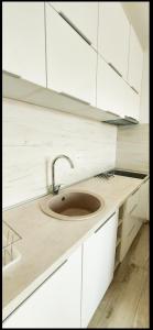 a kitchen with a sink and white cabinets at Artemis Apartment in Ulcinj