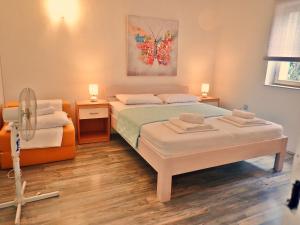 a bedroom with two beds and a fan at Apartman Amarena in Starigrad-Paklenica