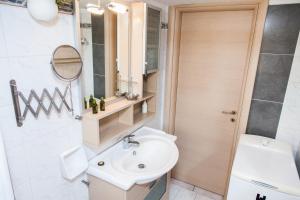 a bathroom with a sink and a toilet and a mirror at Amazing apartment with view! in Piraeus