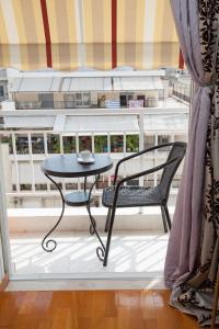 a table and a chair sitting on a balcony at Amazing apartment with view! in Piraeus