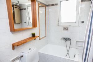 a bathroom with a tub and a toilet and a window at Amazing apartment with view! in Piraeus