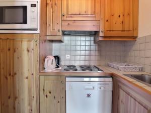 cocina con armarios de madera y horno con fogones en Appartement Méribel, 2 pièces, 5 personnes - FR-1-182-104 en Méribel