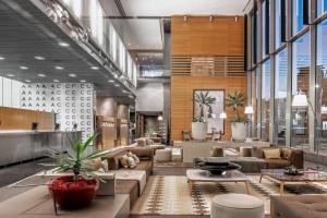 a lobby with couches and tables and plants at AC Hotel Barcelona Fórum by Marriott in Barcelona