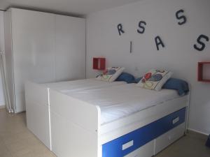 Cama blanca en una habitación con letreros en la pared en Auremar en Puerto del Carmen