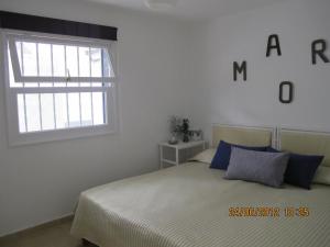 Habitación blanca con cama y ventana en Auremar, en Puerto del Carmen